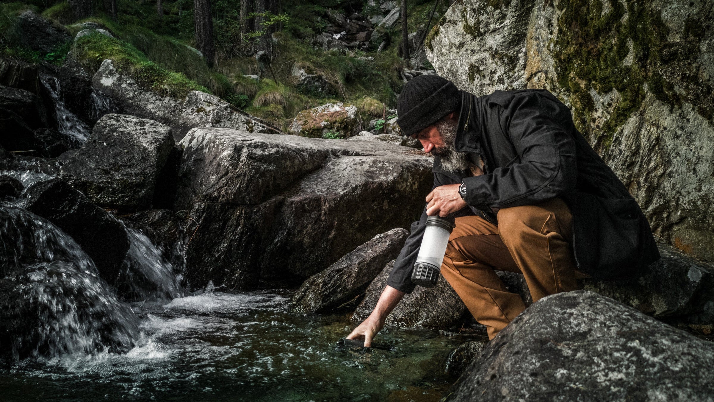 Alex Wander, Grayl Ambassador, purifying water in the Italian Alps with his Covert Black UltraPress.