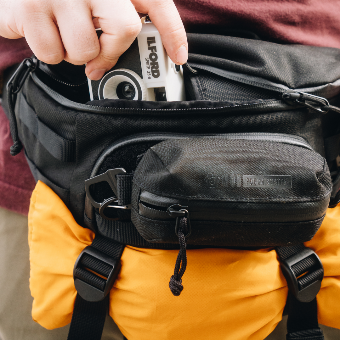 Interior photo of main compartment of 2L Grayl Transport Hip Pack in Covert Black with extra layer in BottleLock Tie Down System.