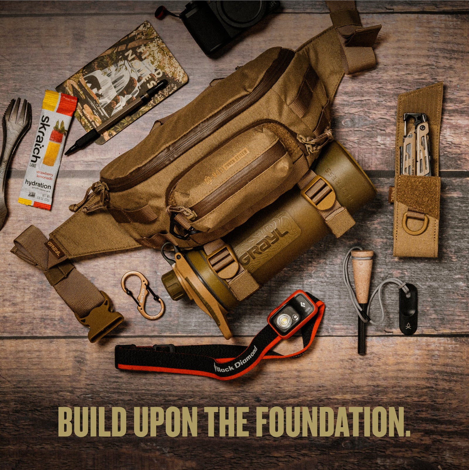 Flat lay on wood depicting 4L Grayl Transport Hip Pack, G-MOD Pod Pouch,Multi-Tool Pouch, and GeoPress Water Filter Purifier Bottle all in Coyote Brown Colorway.